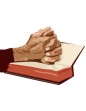 man praying with his hands on a bible