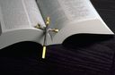  a cross lying across a Bible